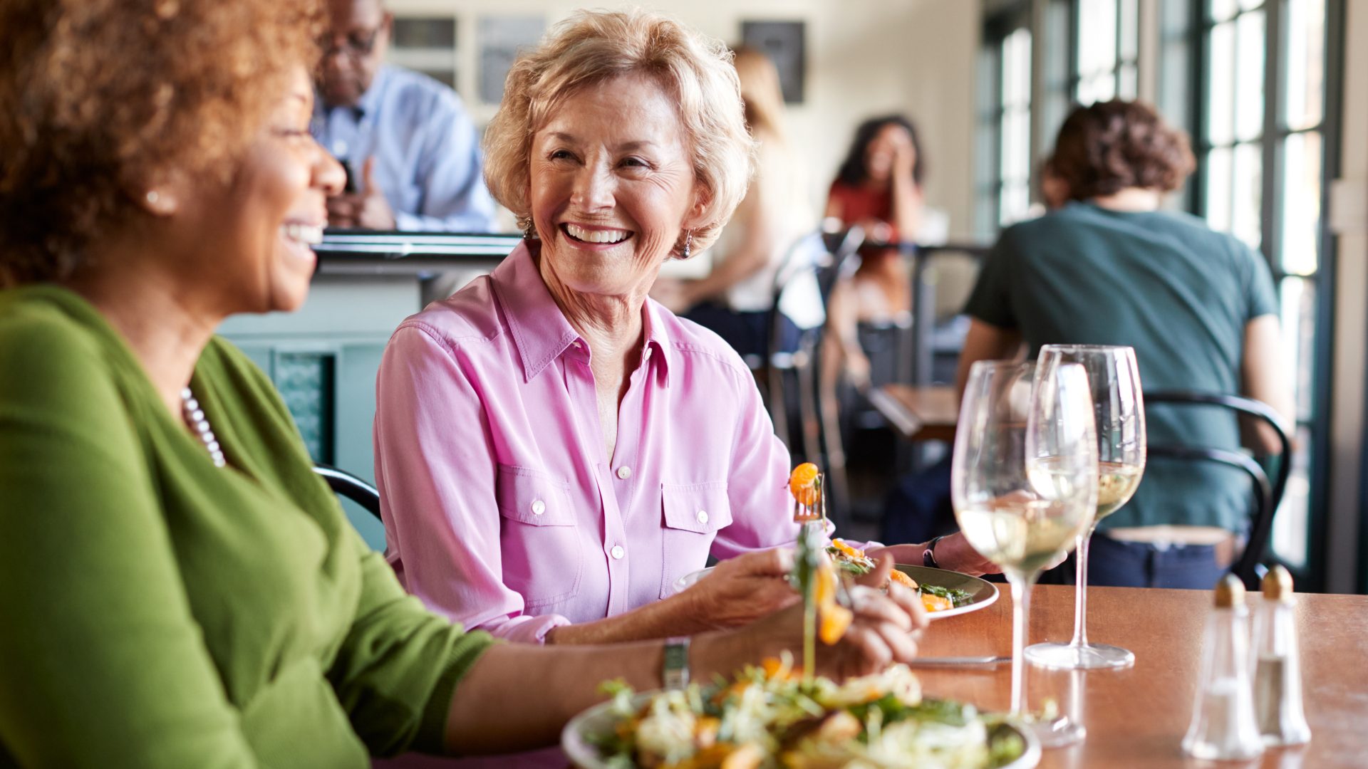 two women sitting at a table with a plate of food at The Hudson Oaks