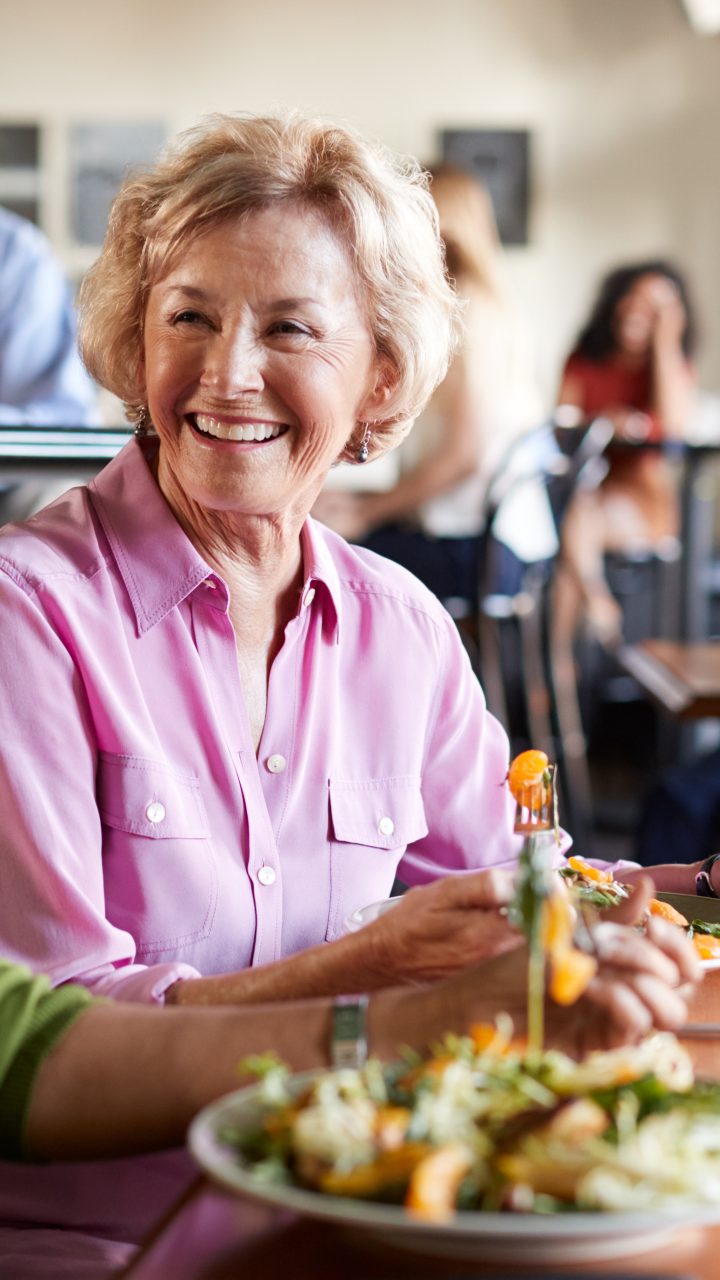 two women sitting at a table with a plate of food at The Hudson Oaks