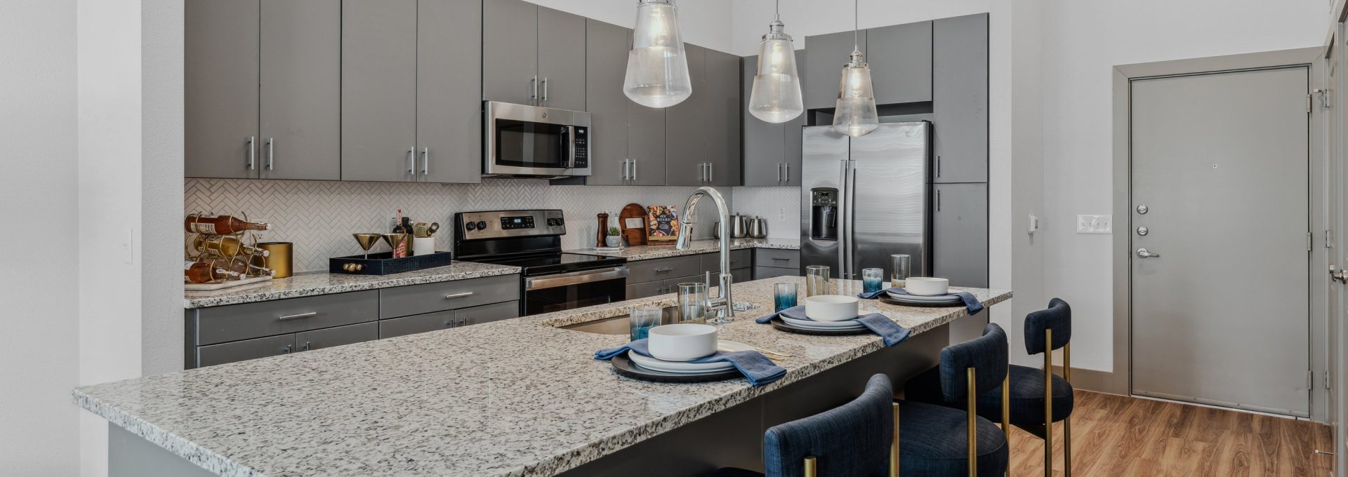 a kitchen with stainless steel appliances and granite counter tops at The Hudson Oaks