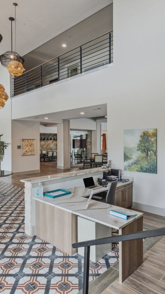 the lobby of a modern apartment building with a staircase at The Hudson Oaks